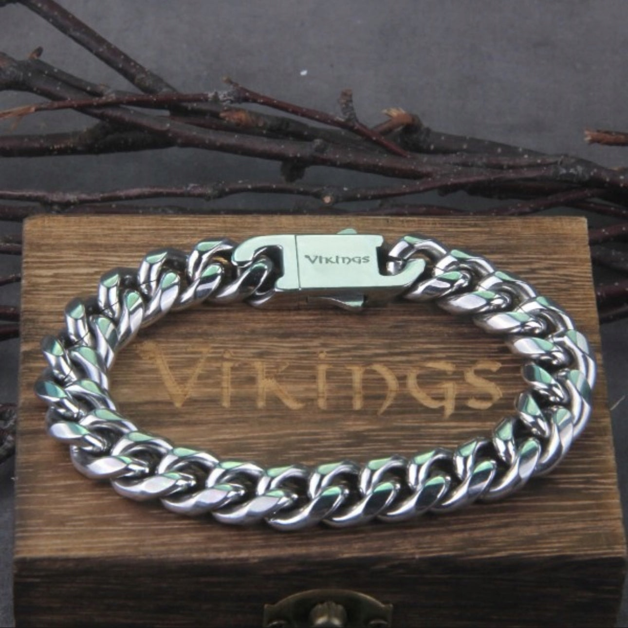 Maskulint vikingarmbånd i kirurgisk stål 316L, sølvfarget med kraftig lenke (21 cm lengde, 1,5 cm bredde). Solid lås med “Vikings”-gravering, pakket i en eksklusiv tre-eske. Perfekt som gave eller et stilfullt tilbehør for menn som elsker vikingstil. Rustfritt, allergivennlig og slitesterkt design.