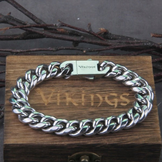 Maskulint vikingarmbånd i kirurgisk stål 316L, sølvfarget med kraftig lenke (21 cm lengde, 1,5 cm bredde). Solid lås med “Vikings”-gravering, pakket i en eksklusiv tre-eske. Perfekt som gave eller et stilfullt tilbehør for menn som elsker vikingstil. Rustfritt, allergivennlig og slitesterkt design.