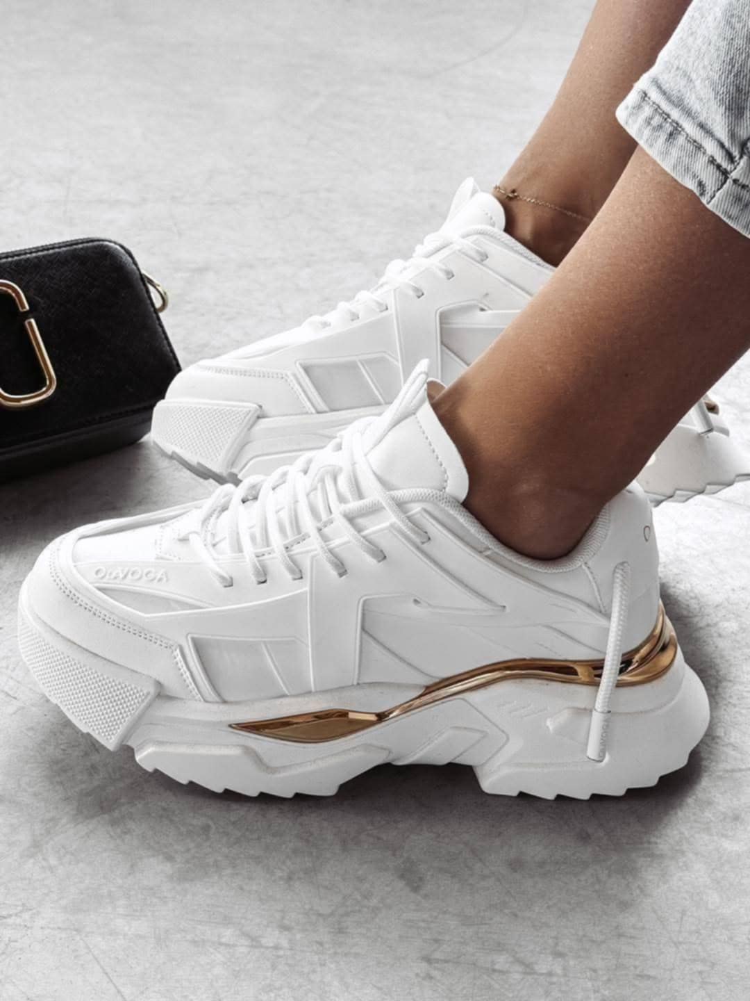 Ola Voga Sneaker White – trendy hvite sneakers med stilige gulldetaljer. Laget av slitesterkt tekstil og syntetisk skinn for optimal komfort. Tykk, plattformaktig gummisåle gir ekstra høyde og støtte. Tilgjengelig i størrelser 36-41 (36 = 23,9 cm, 41 = 27,3 cm). Perfekte for en sporty og motebevisst look!